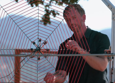 Man using a harp shaped like a spiderweb